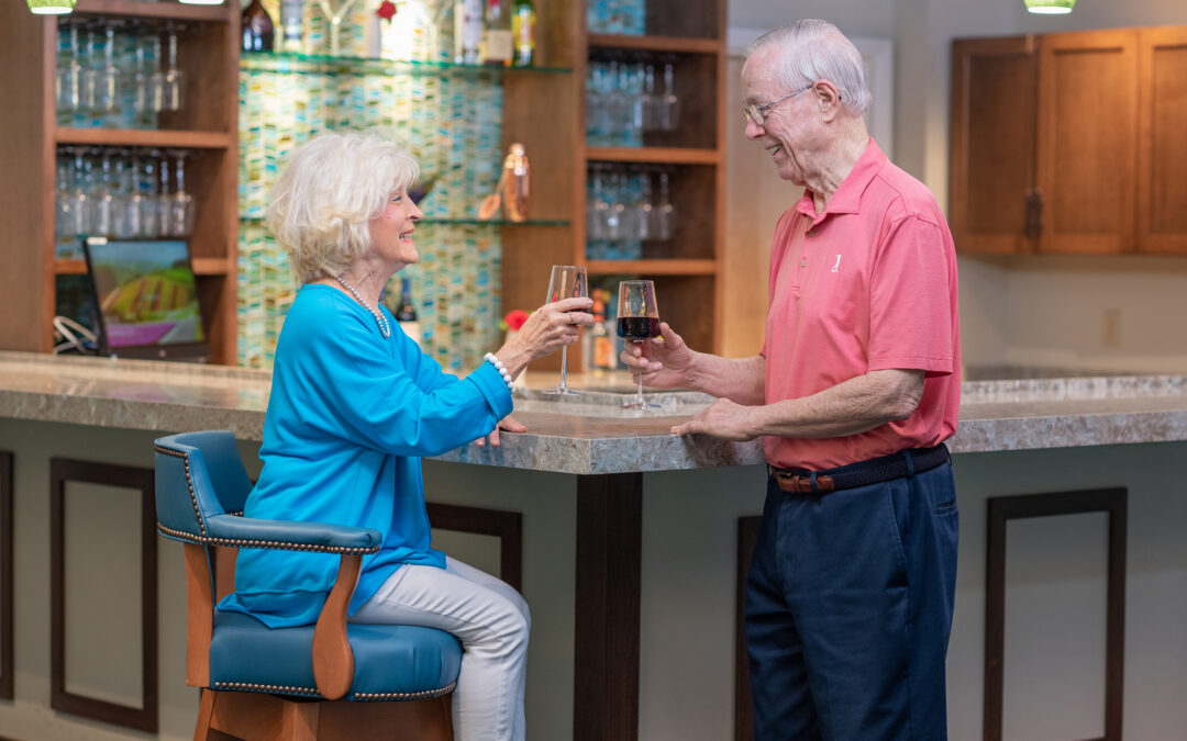 A couple clinks their glasses together at the bar.