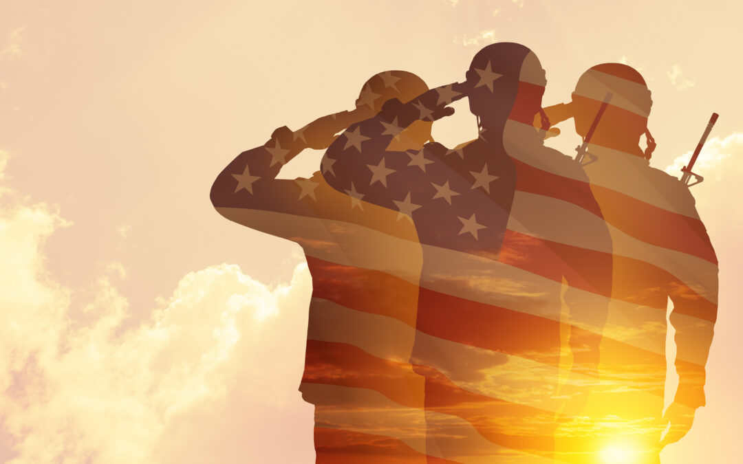 Silhouettes of soldiers with print of sunset and USA flag saluting on a background of light sky.