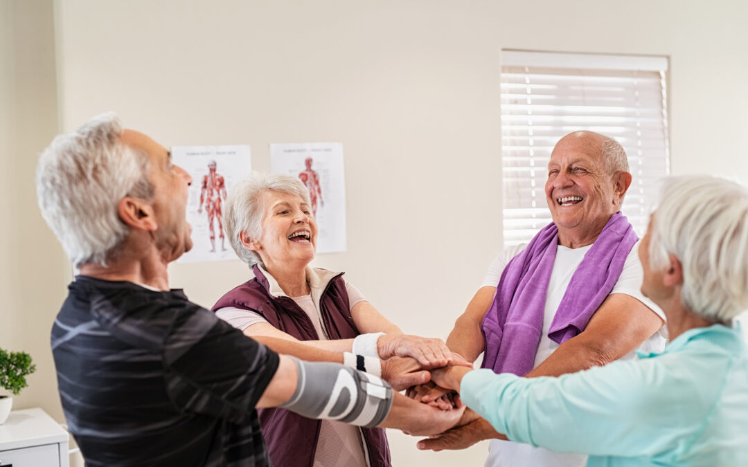 Laughing senior people putting hands together after workout.