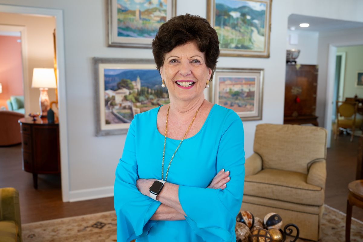 Susan Hamilton stands smiling in her beautiful home at The Mayflower.